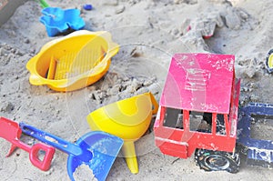 ChildrenÃ¢â¬Ës bright plastic toys in sandpit sand